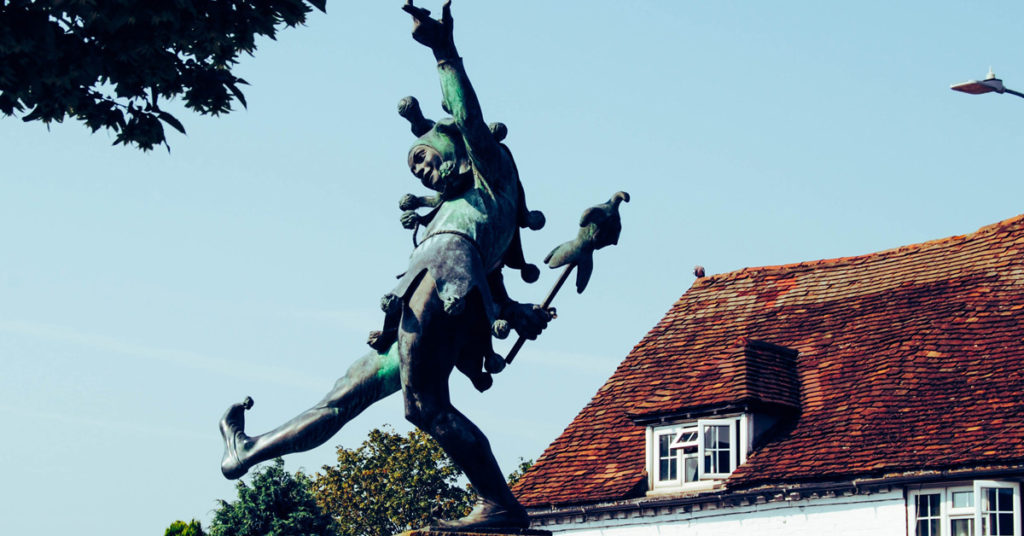 A green statue shows the archetype of the fool.