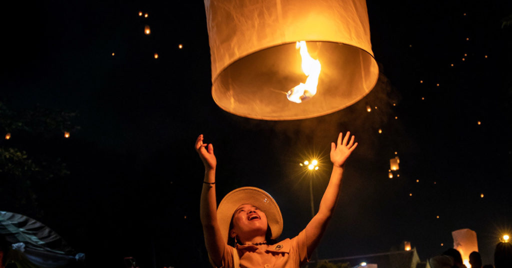 A child releases a candle in a balloon, illustrating the idea of Letting Go.